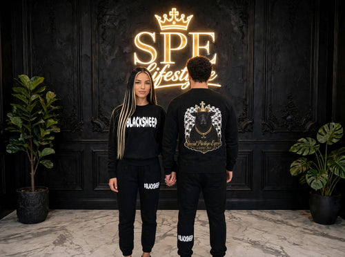 Man and woman wearing black #BLACKSHEEP sweatshirts and joggers on a city street